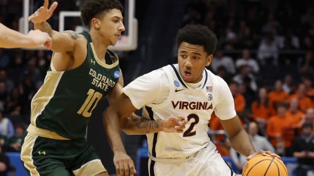 Reece Beekman drives the ball with Nique Clifford defending during the Virginia men's basketball game against Colorado State in the First Four of the NCAA Men's Basketball Tournament at UD Arena in Dayton, Ohio.